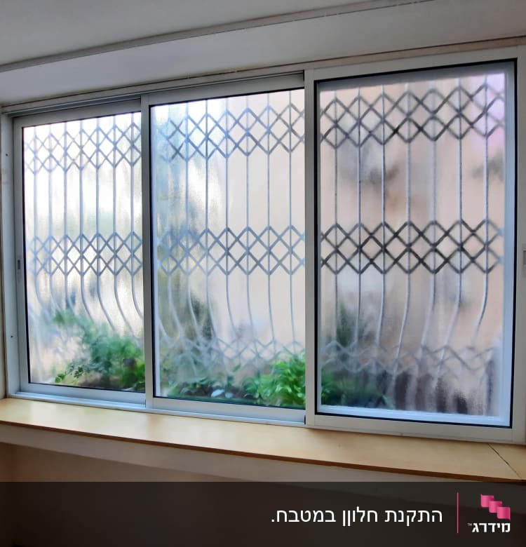 חלון אלומיניום עם זכוכית מטושטשת וסורגים דקורטיביים